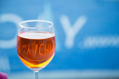 Aperol-Glas vor dem verschwommenen Yacht-Urlaub Logo